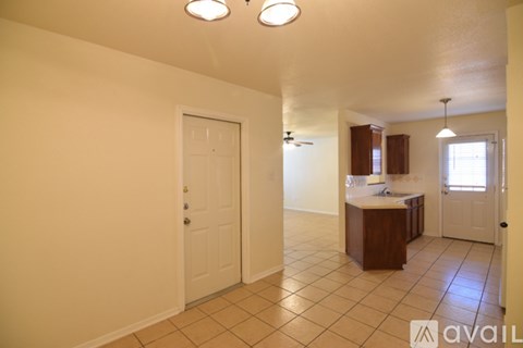 A kitchen area with a sink, cabinets, and a door.