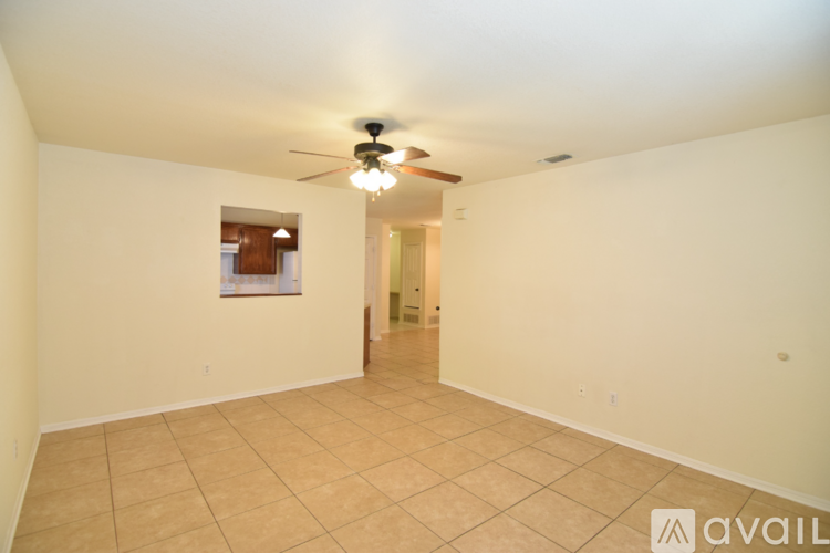 A spacious room with a ceiling fan and tiled floor.