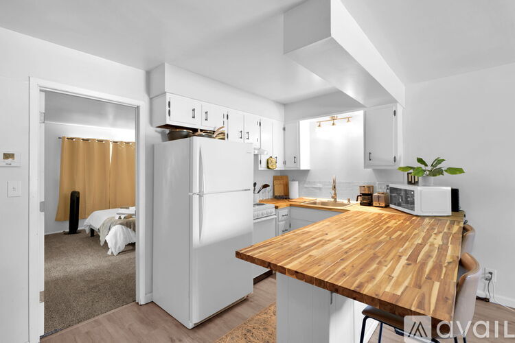 A kitchen with a wooden table and white appliances.
