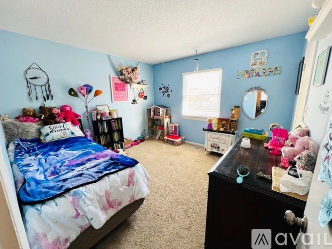 A bedroom with a bed, dresser, and a mirror on the wall.