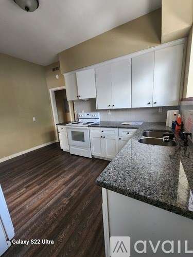 A kitchen with white cabinets and a granite countertop.