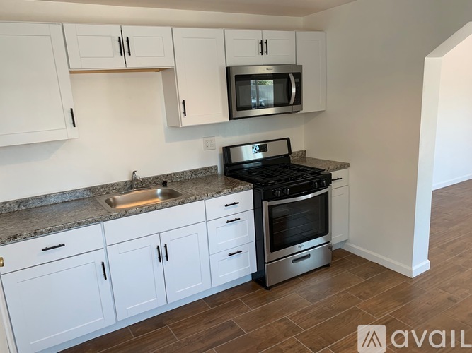 A kitchen with white cabinets and a black stove top oven.