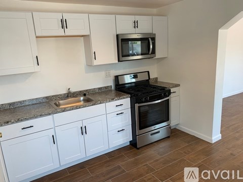 A kitchen with white cabinets and a black stove top oven.