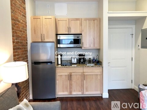 A kitchen with wooden cabinets and a refrigerator.