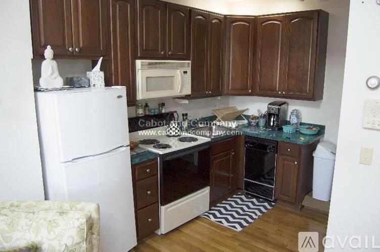 A kitchen with brown cabinets and a white refrigerator.