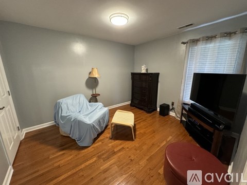 A living room with a blue sofa and a wooden floor.