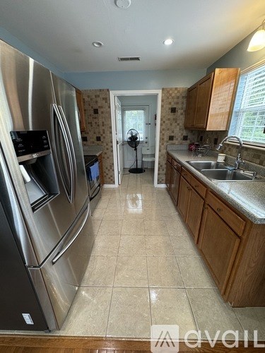 A kitchen with a stainless steel refrigerator and a sink.