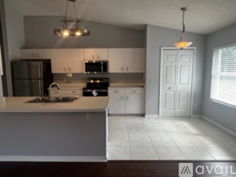 A kitchen with white cabinets and a white door.