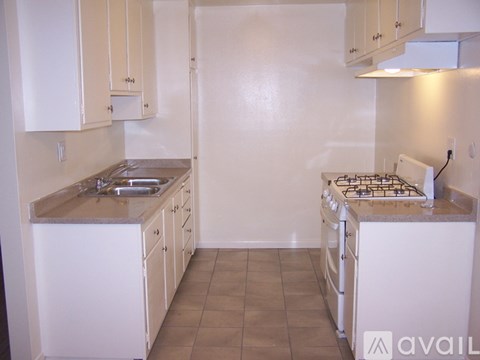 A kitchen with white cabinets and a white stove.