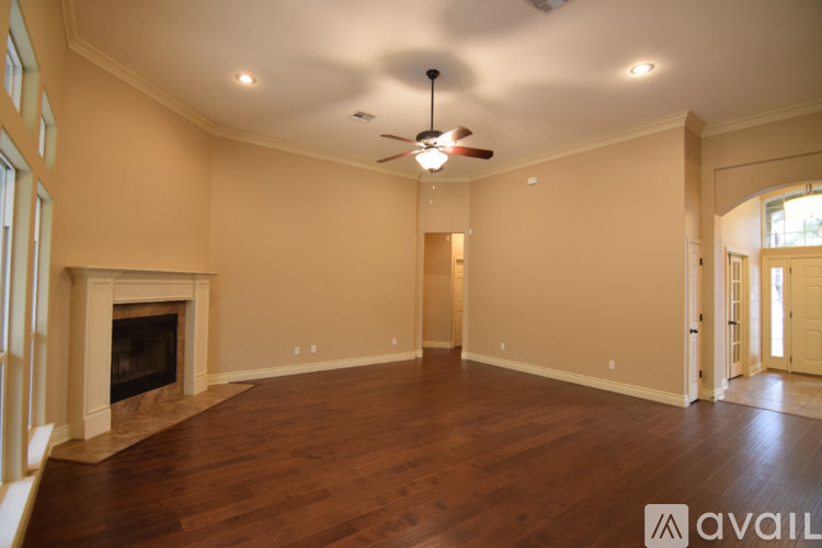 A spacious room with a fireplace and a fan on the ceiling.