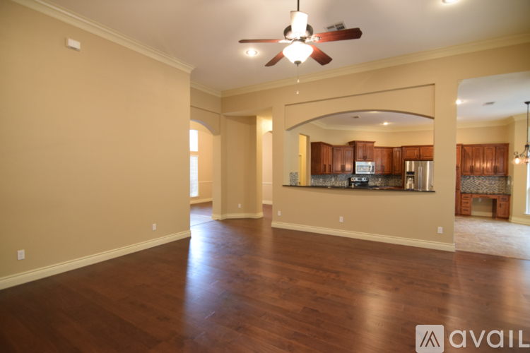 A spacious living room with hardwood floors and a ceiling fan.