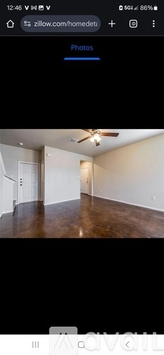 A room with a ceiling fan and wooden flooring.