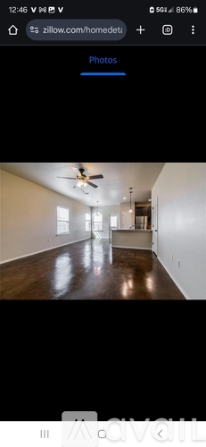 A room with a ceiling fan and wooden flooring.