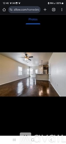 A room with a ceiling fan and wooden flooring.