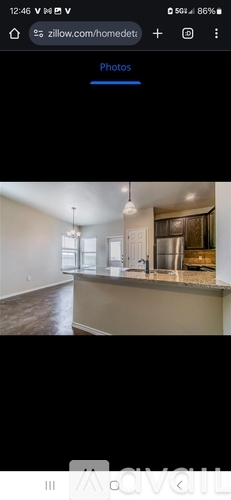 A room with a kitchen counter and a refrigerator.