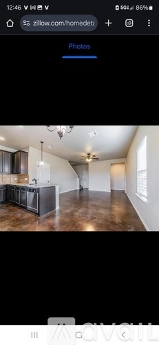 A room with a ceiling fan and a large open space.