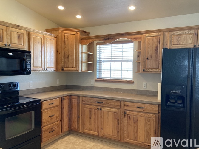 A kitchen with wooden cabinets and black appliances.