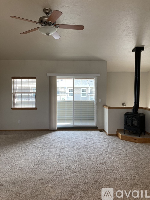 A room with a fan, a wood stove, and a window.