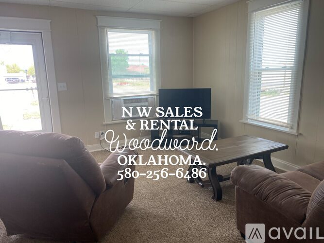 A living room with a sign for NW Sales & Rental Woodward, Oklahoma.