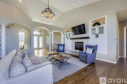 A living room with a white couch and a striped rug.
