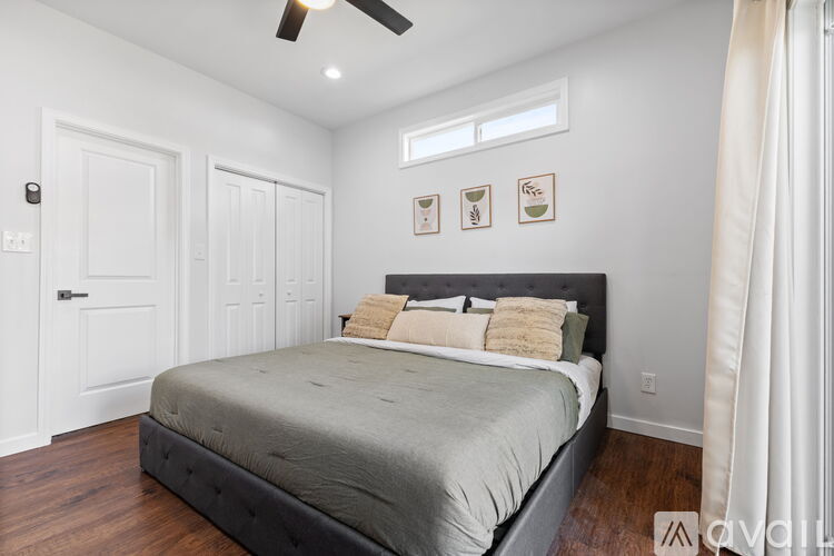 A bedroom with a large bed and a ceiling fan.