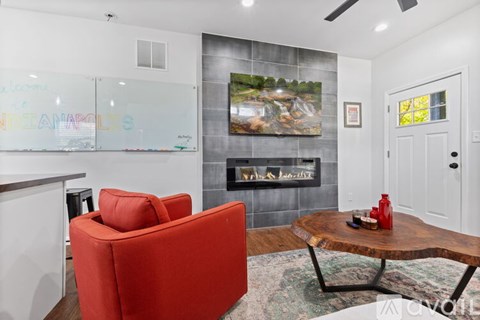 A living room with a red chair and a wooden coffee table.