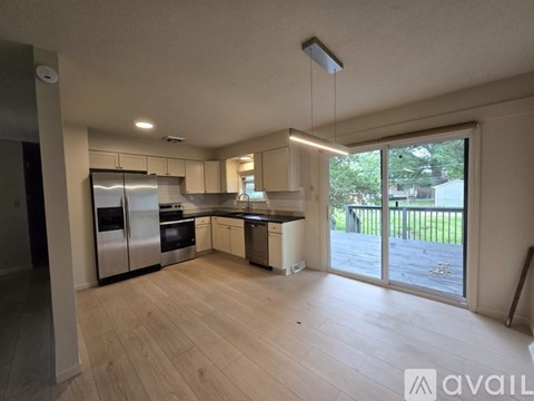 A kitchen with wooden floors and stainless steel appliances.