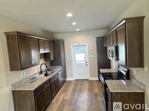 A kitchen with brown cabinets and granite countertops.