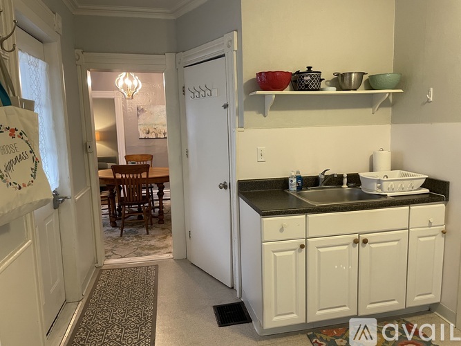 A kitchen with white cabinets and a black countertop.