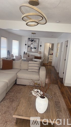 A living room with a white sofa and a wooden coffee table.