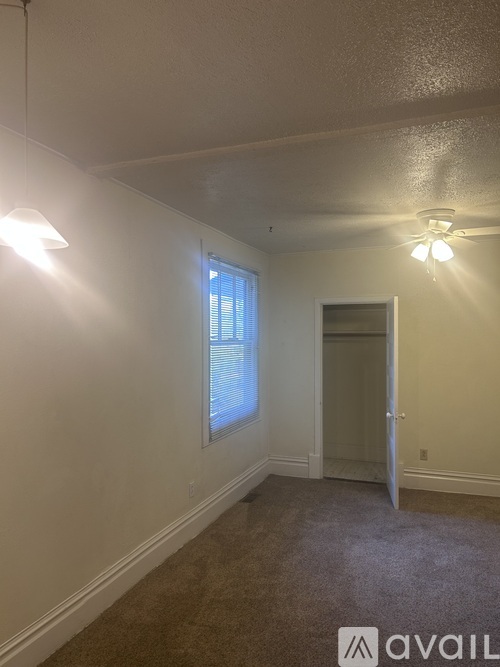 A room with a carpeted floor and a door leading to another room.