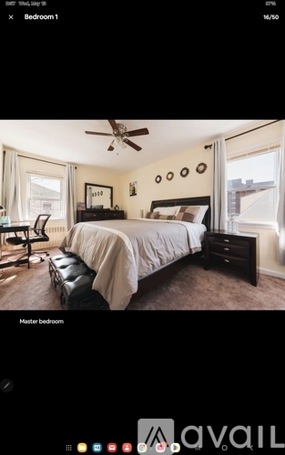 A bedroom with a bed, chair, and a ceiling fan.