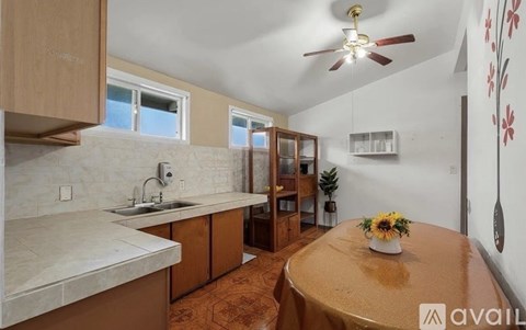 A kitchen with a table and a fan.