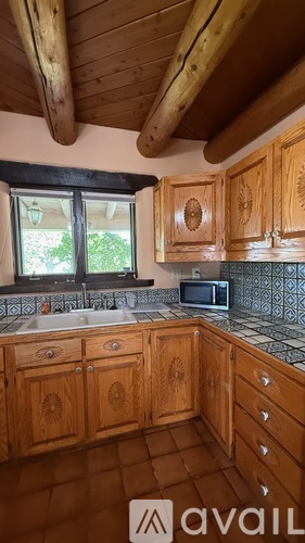 A kitchen with wooden cabinets and a black countertop.