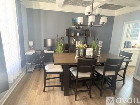A dining room with a wooden table and chairs.