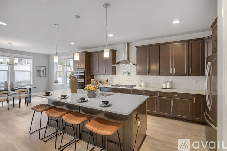 A modern kitchen with brown cabinets and a large island.