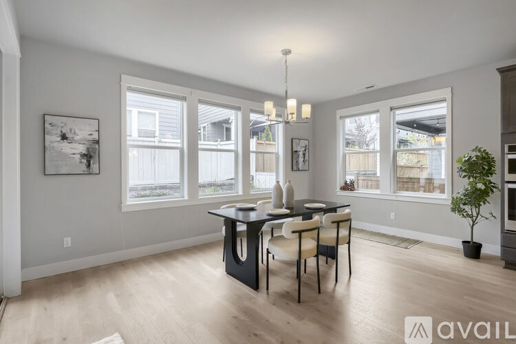 A dining room with a table and chairs and a plant.