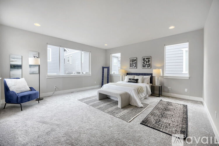 A bedroom with a large bed and a blue chair.