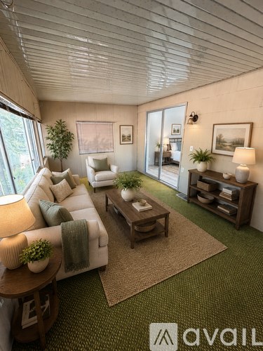 A living room with a white couch, a wooden coffee table, and a rug with the Avail logo on it.