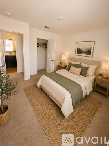 A bedroom with a large bed and a painting on the wall.