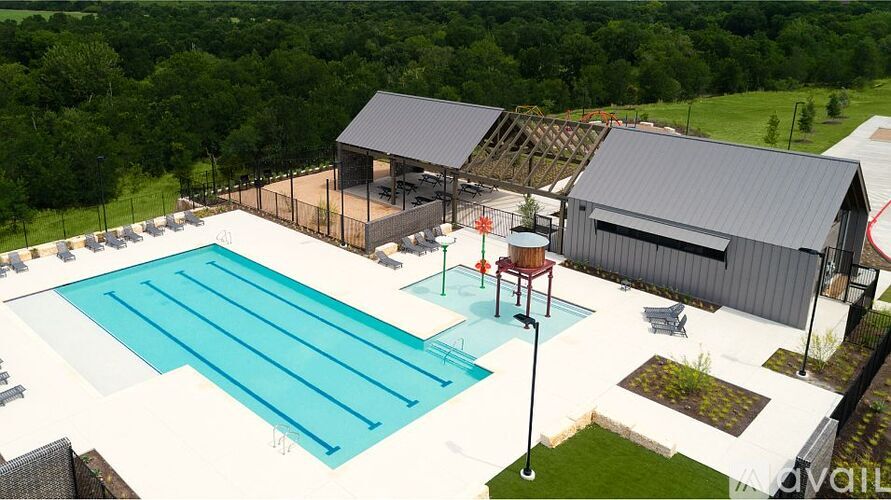 A large outdoor swimming pool with a diving board and a building in the background.