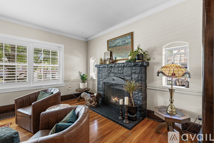 A living room with a fireplace and a painting on the wall.