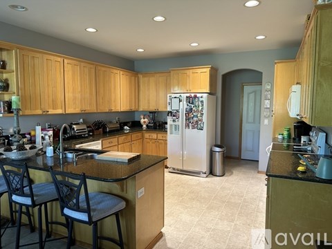 A kitchen with wooden cabinets and a black countertop.
