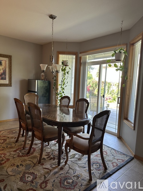 A dining room with a table and chairs.