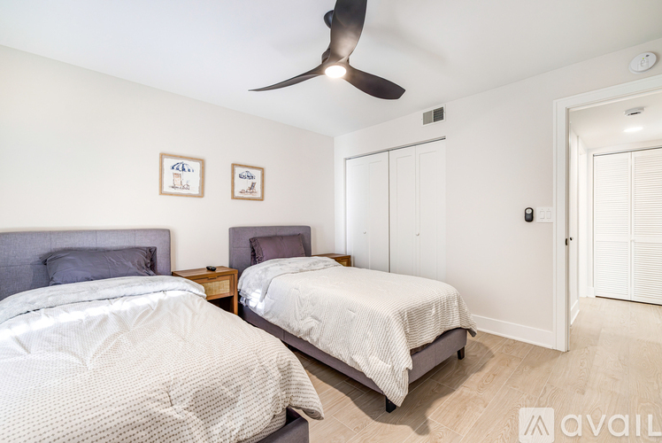 A bedroom with two beds and a ceiling fan.