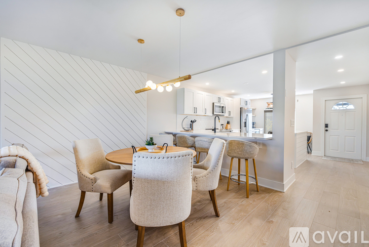 A modern dining room with a wooden table and chairs.