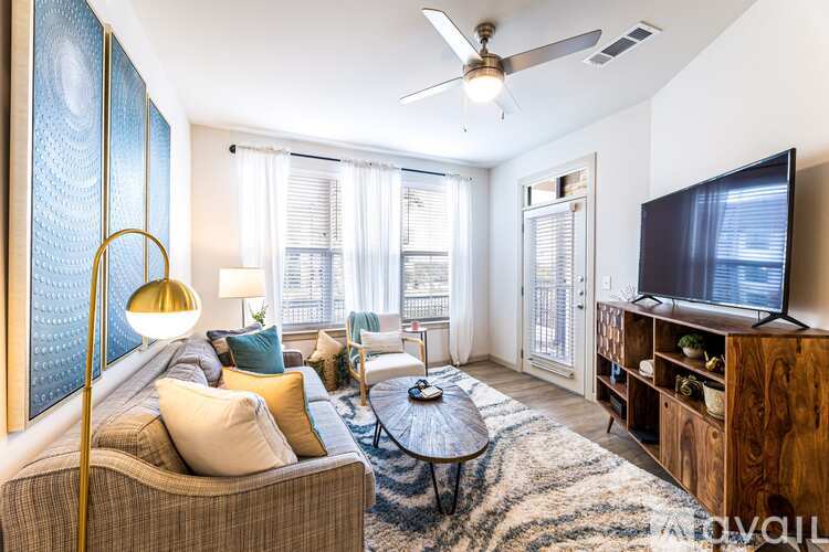 A living room with a couch, a coffee table, a television, and a floor lamp.