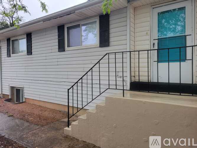 A house with a black railing and a white door.