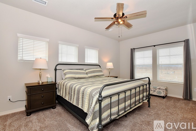 A bedroom with a bed, nightstand, and window blinds.