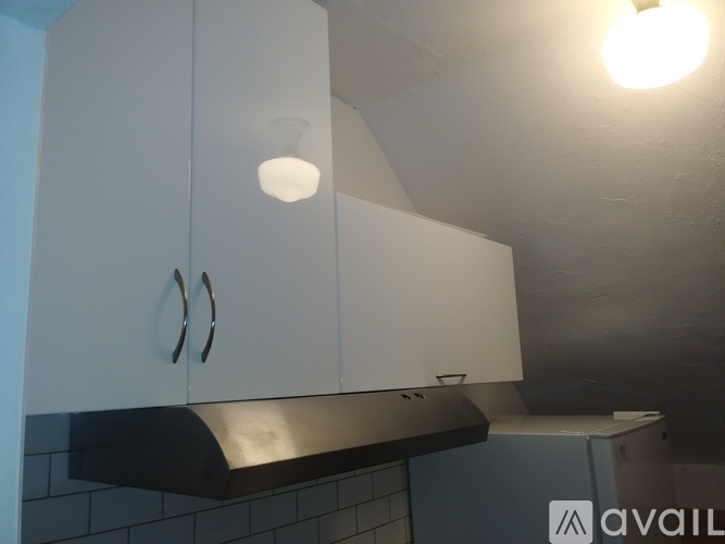A kitchen with white cabinets and a black counter.